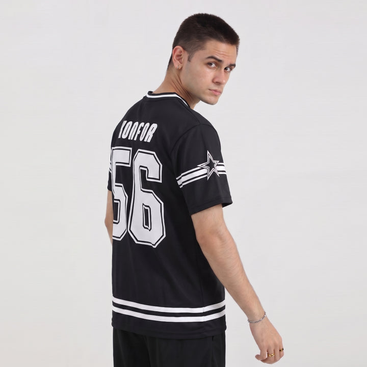 Man wearing a black sports jersey with white lettering and numbers on a plain background
