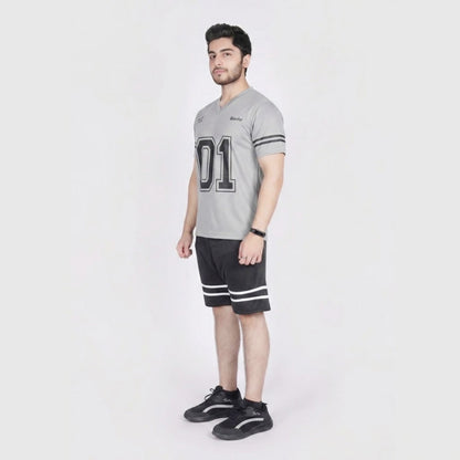 A man modeling a light gray v-neck athletic t-shirt with '01' printed on the front, paired with black athletic shorts featuring white stripes, and black sneakers, against a plain light gray background.