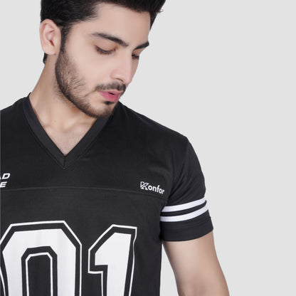 Man wearing a black sports jersey with white lettering on a plain background