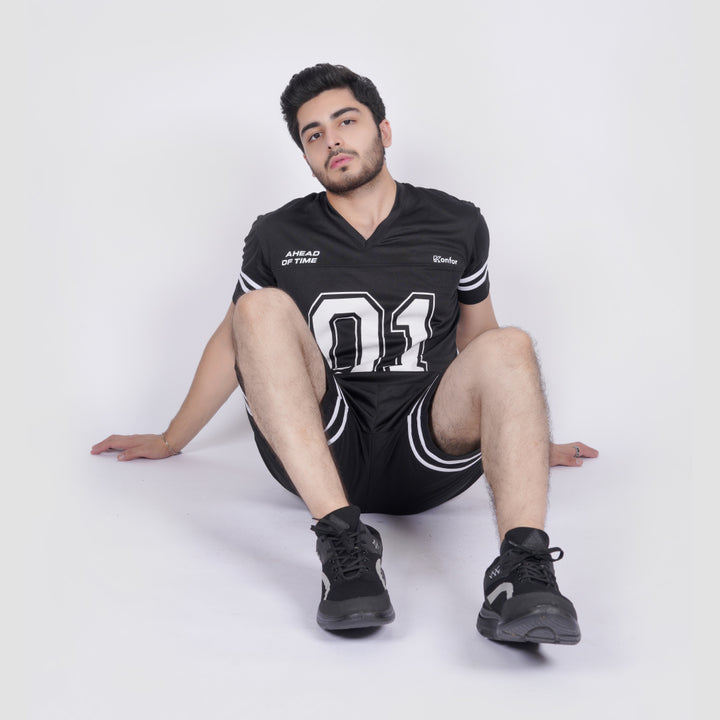 Person wearing a black sports outfit with white text and numbers on a white background