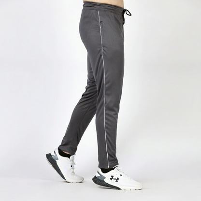 Gray athletic pants with white stripes worn by a person on a white background