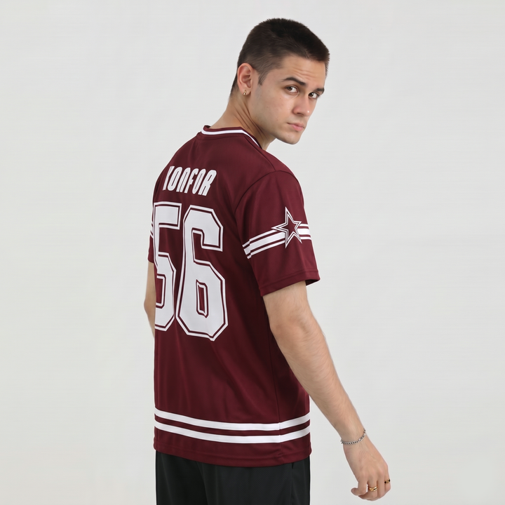Man wearing a maroon sports jersey with white lettering and numbering on a plain background
