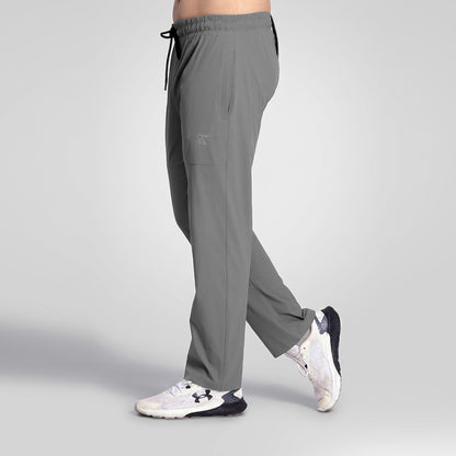 A person wearing gray athletic jogger-style pants with a drawstring waist and side cargo pocket, shown from the waist down against a light gray studio background. The pants are the product, while the visible shoes are incidental styling.
