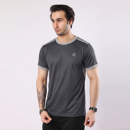 Man wearing a dark gray athletic shirt with a logo on a white background