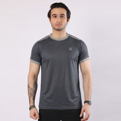 Man wearing a gray athletic shirt with a logo on a white background