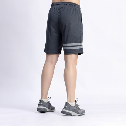 Person wearing dark gray shorts with reflective stripes on a white background