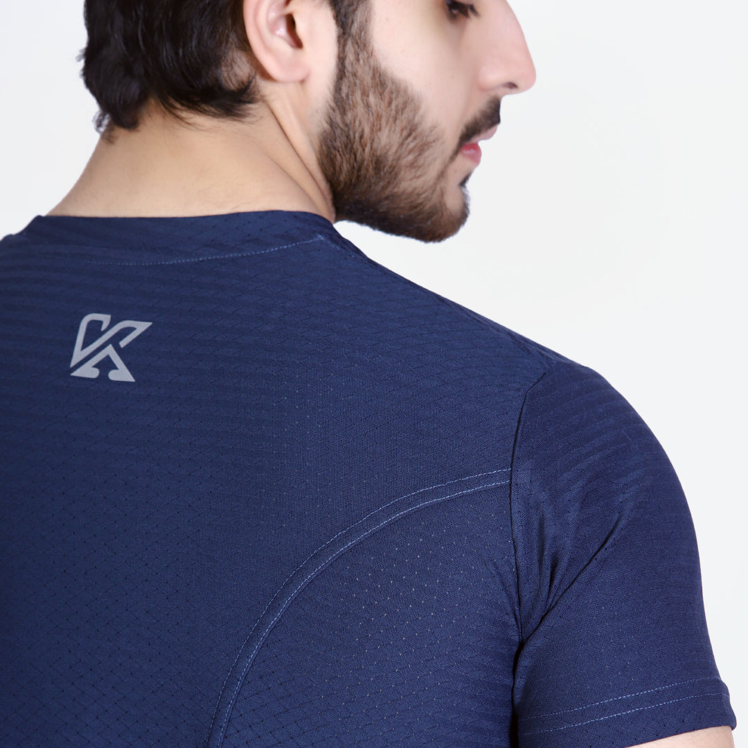 Navy blue athletic shirt with a logo on the back, worn by a person.