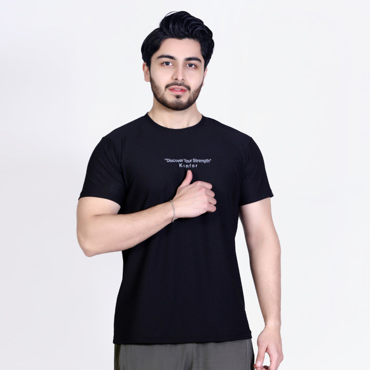 Man wearing a black t-shirt with text on a plain background